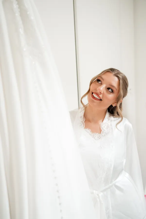 Getting ready beside the hanging gown, hair softly pinned back